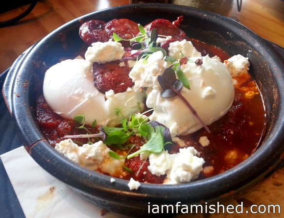 Shakshouka-baked eggs - spicy tomato sauce, leafy greens and crumbled feta.